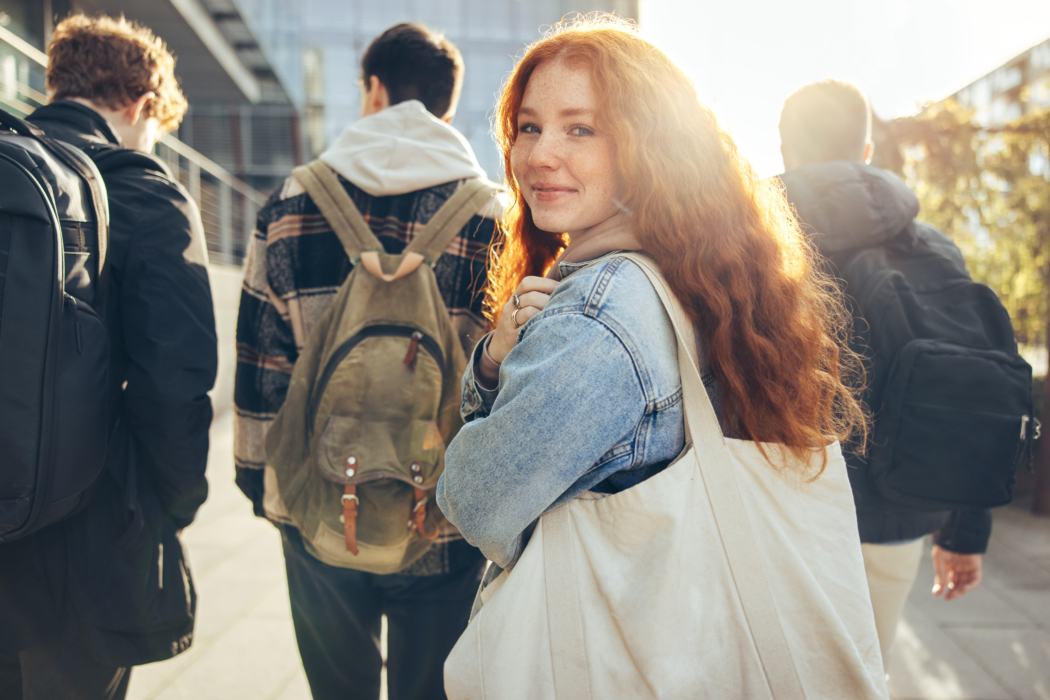 Female student glancing back while going for a class in college.